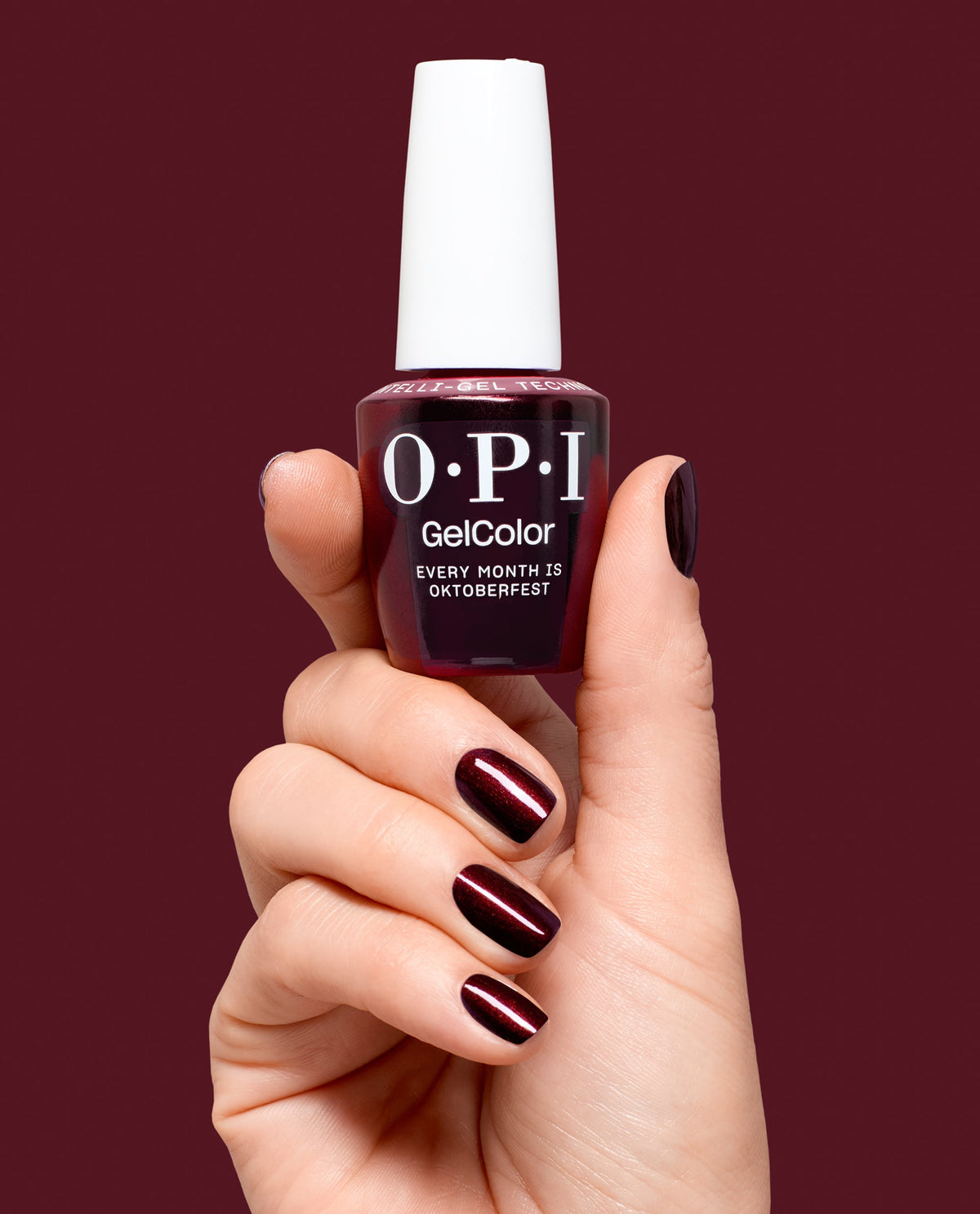 Hand holding OPI Every Month is Oktoberfest gel polish bottle