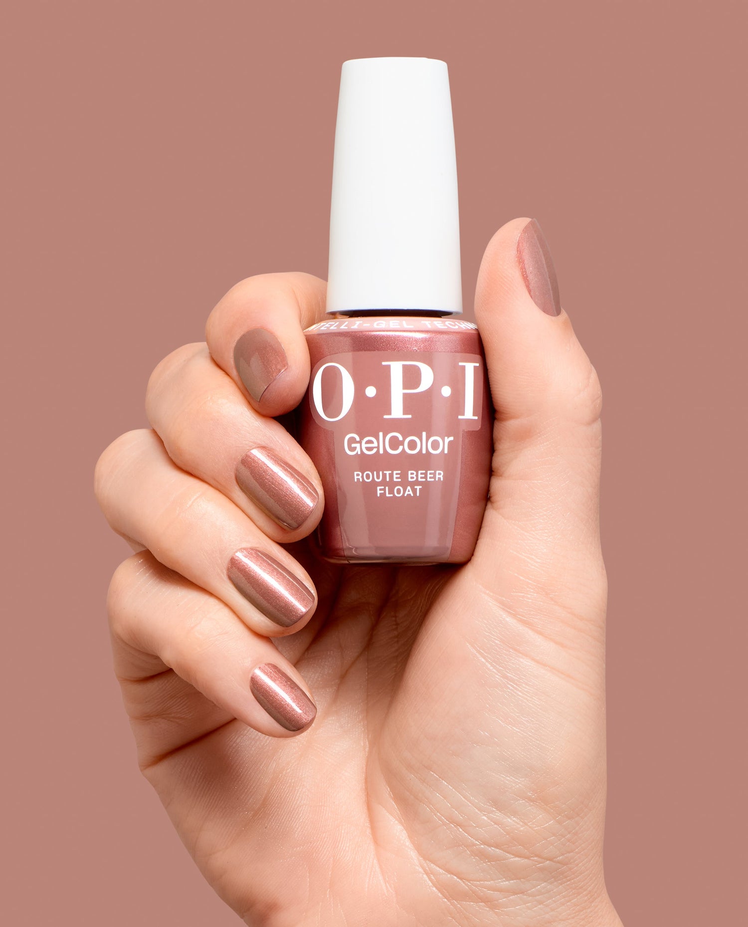 Hand holds OPI GelColor Route Beer Float gel nail polish bottle with matching manicured nails